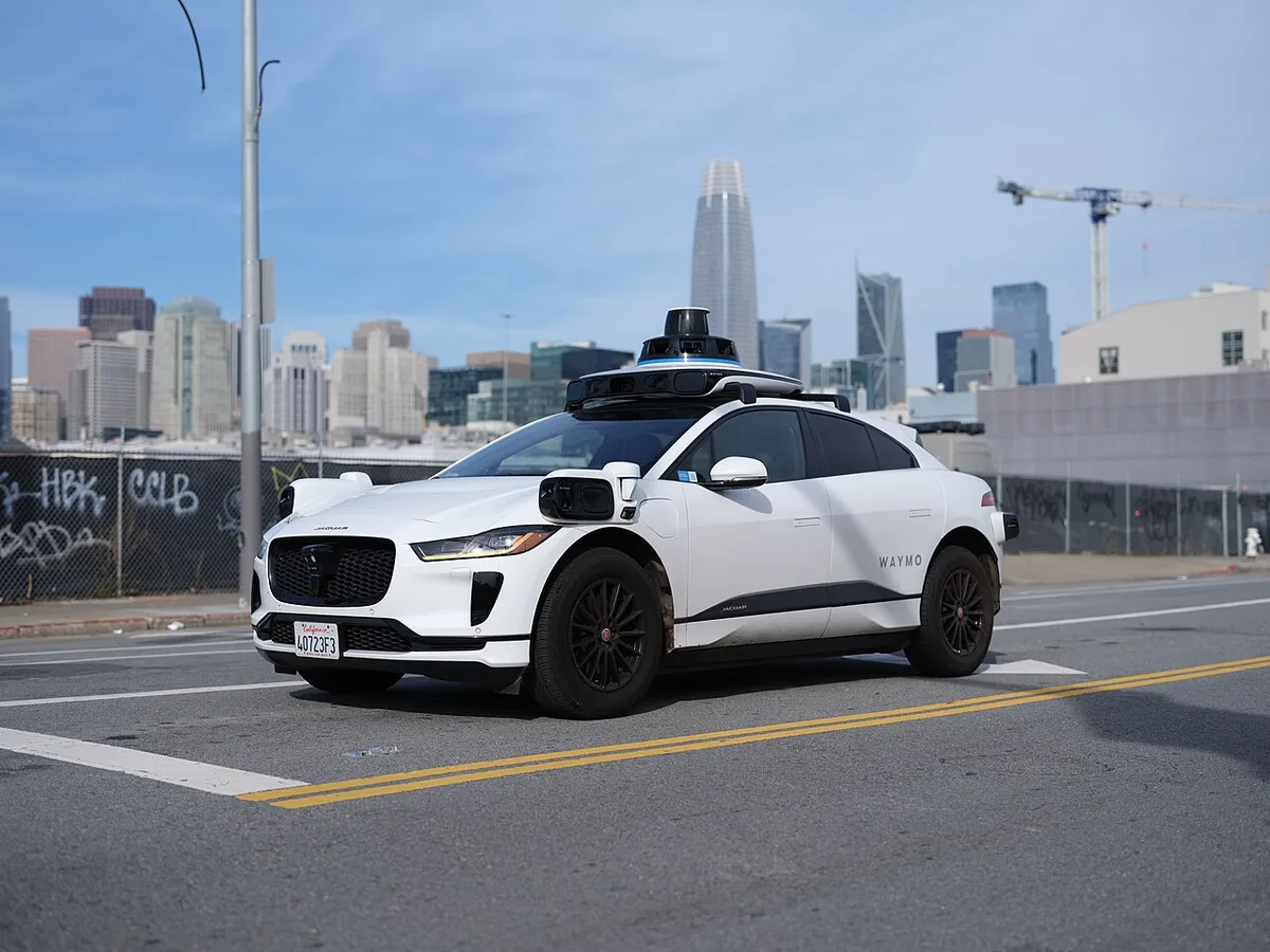 Mobil otonom Waymo berbasis Jaguar I-Pace dengan sensor lidar dan kamera di atap, di jalan San Francisco